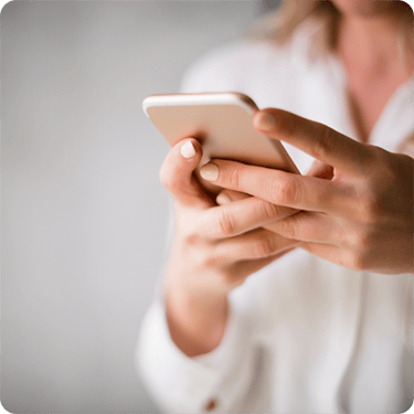 Projektledare arbetar vid dator och mobil med projektdata i Visma Severa. Texten på bilden lyder: Tid- och utläggshantering i Visma Severa.